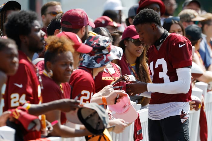 Emmanuel Forbes signs an autograph for Commanders fans